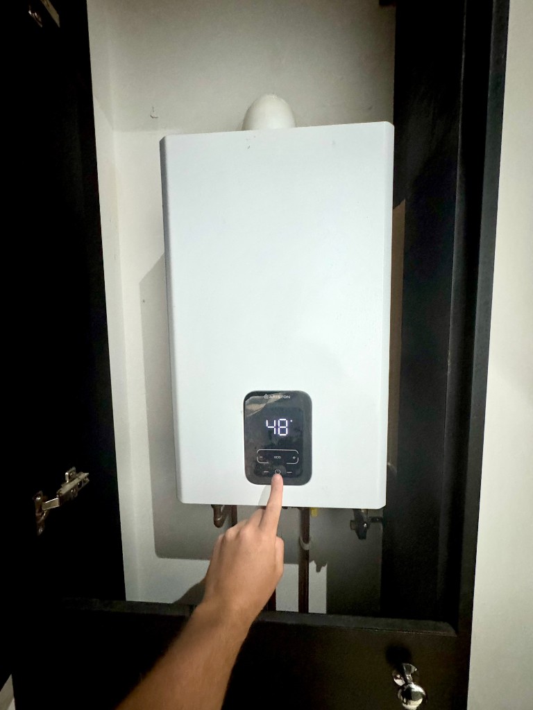 Gas Safe engineer servicing an Ariston boiler control panel
