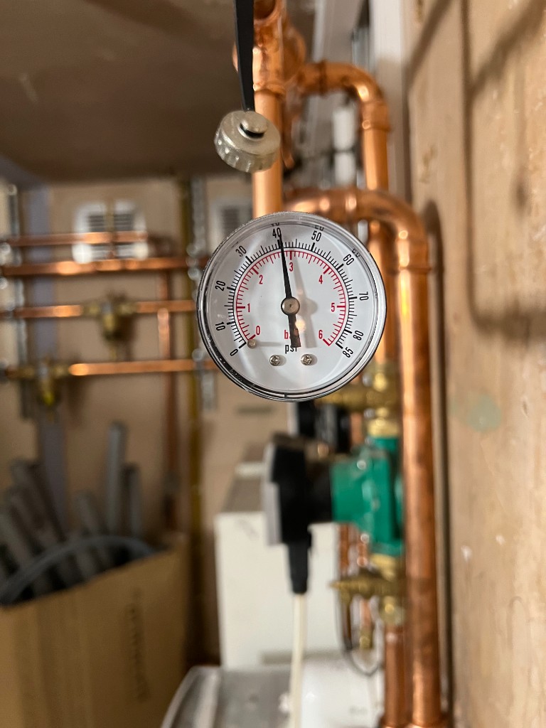 Copper pipework and pressure gauge on a professional plumbing installation